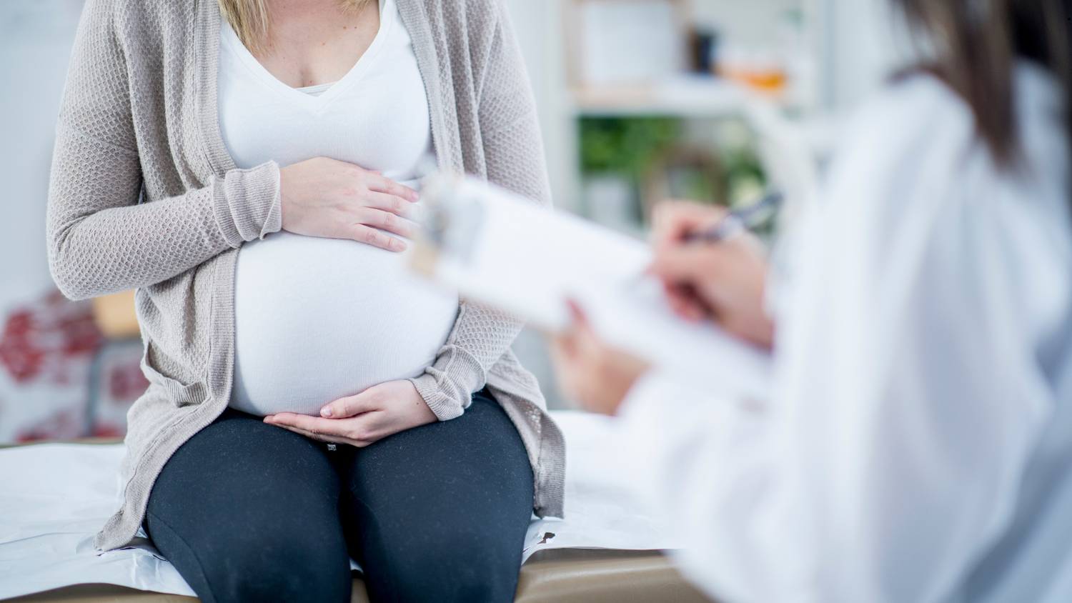 pregnant lady sitting down with medical professional assesing