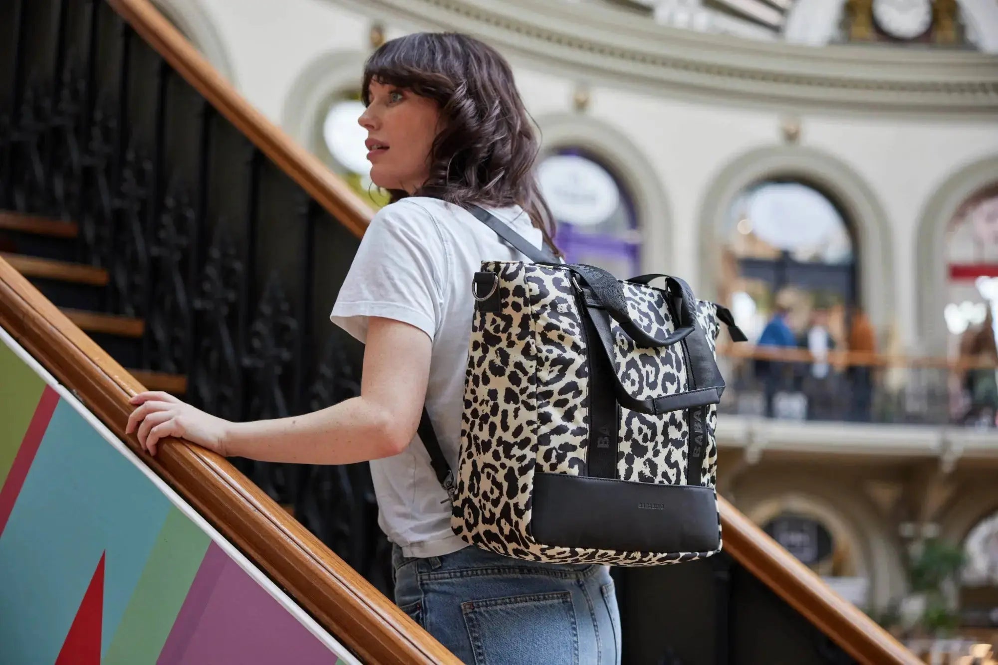 woman modelling leopard print backpack