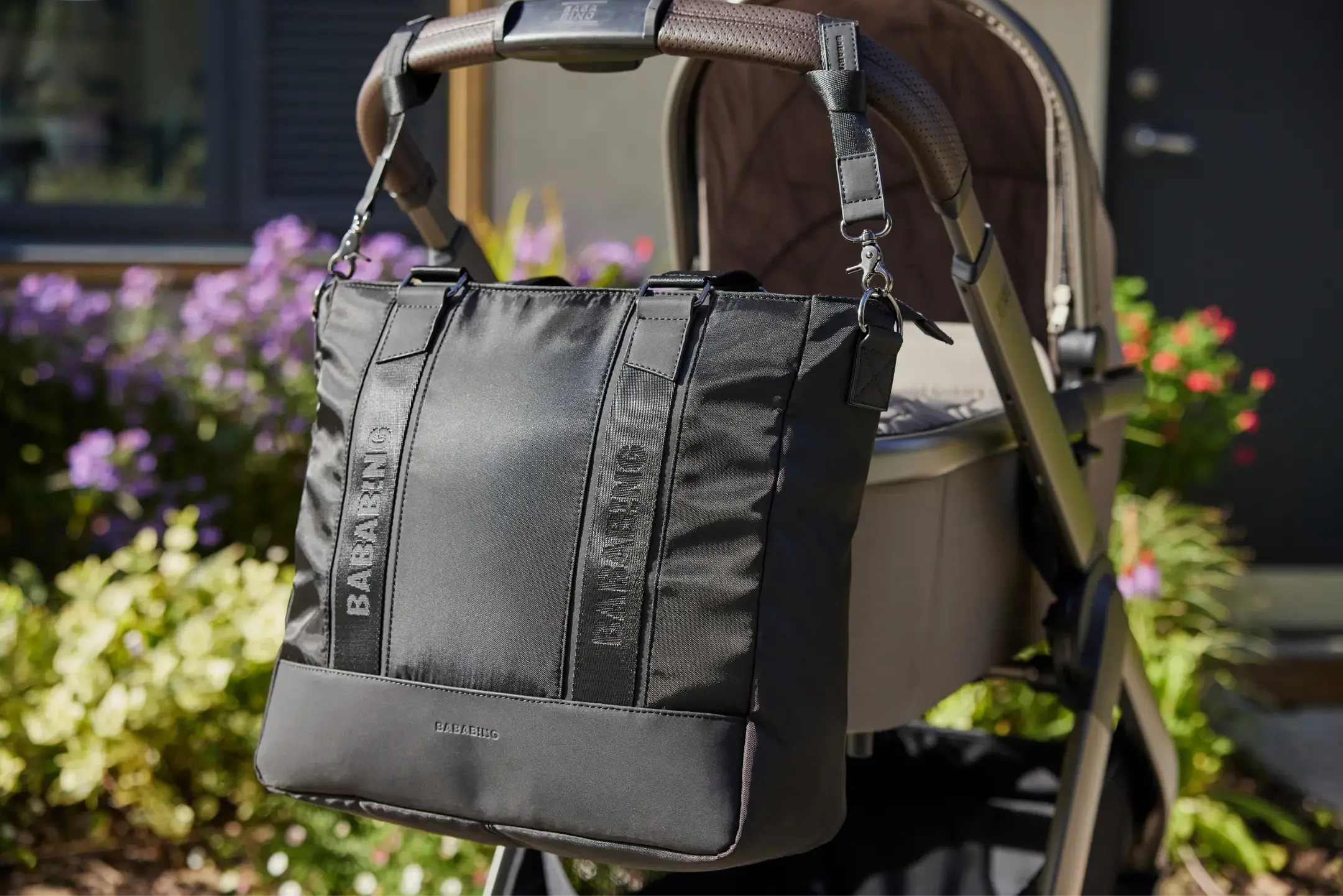 detailed image of a black changing bag with flowers in the background