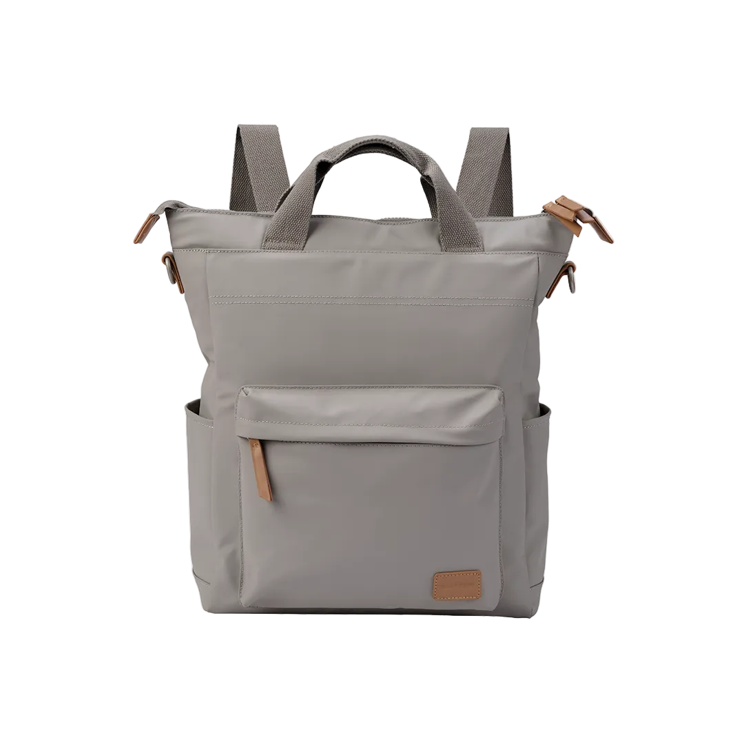 A warm grey Daytripper Pac Changing Bag with a sleek chassis finish and geo-quilted carrycot cover. The bag has multiple pockets and is made from recycled materials.